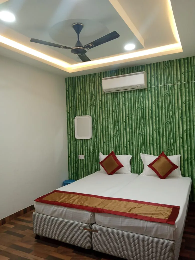 Hotel room with a wall-mounted air conditioner and green bamboo-patterned wallpaper
