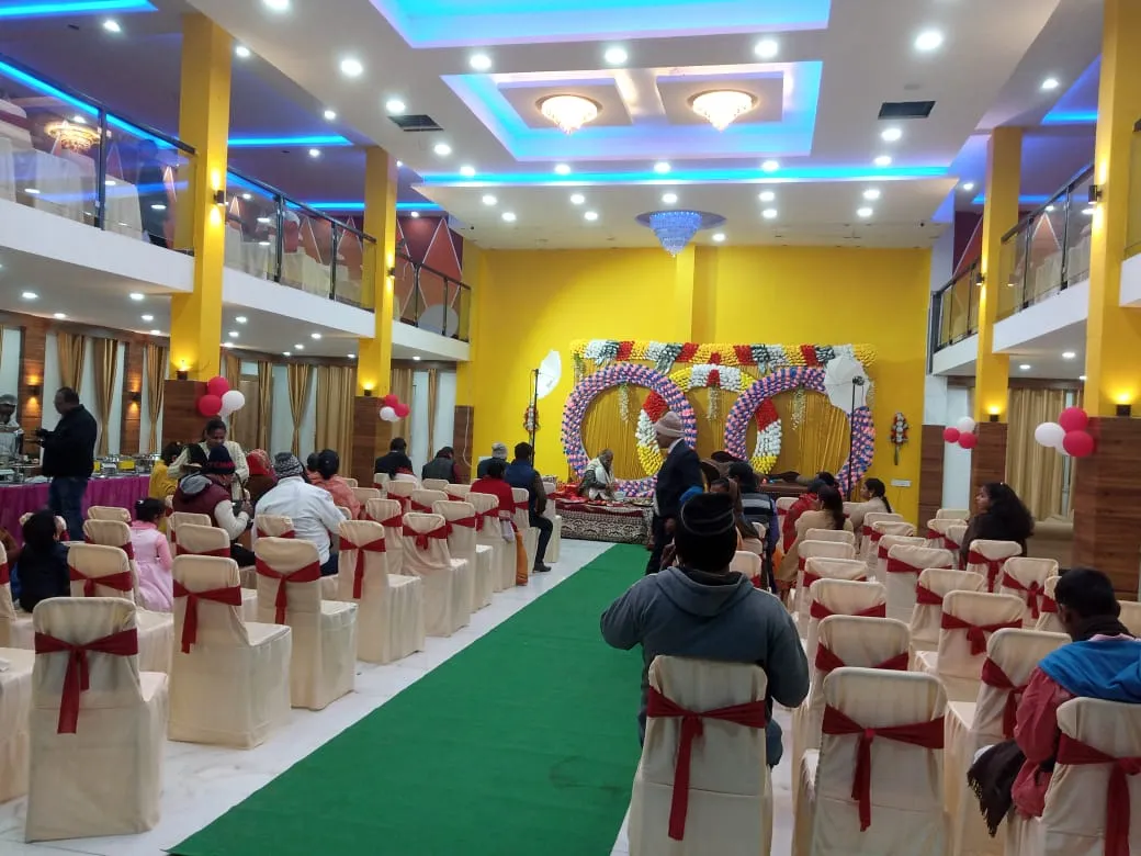 Guests seated in the two-storey banquet hall for a wedding, with an interlocking-rings floral backdrop on stage